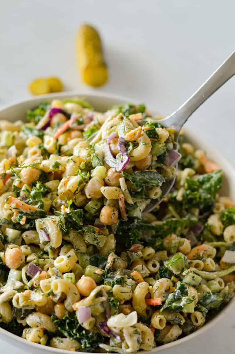 Spooning a dill pickle pasta salad.