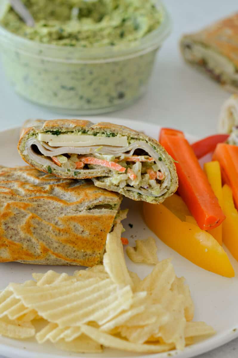 Lunch plate with chips, veggies and cottage cheese wraps.