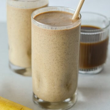 Close up of two glasses of coffee banana smoothies.