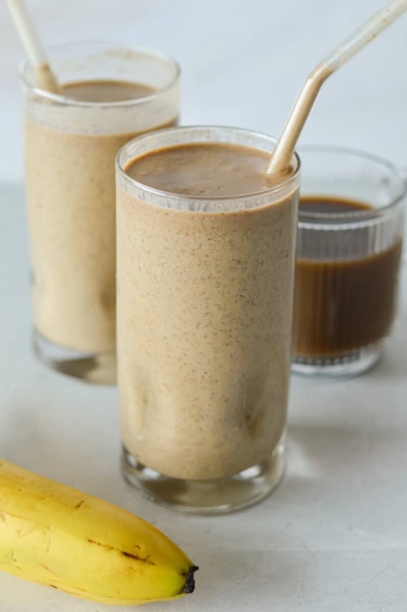Close up of two glasses of coffee banana smoothies.