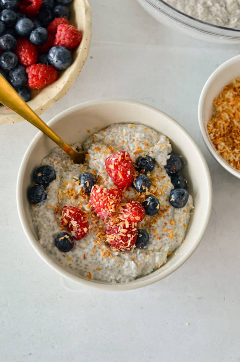 Birds eye of coconut chia pudding topped with berries and shredded coconut.