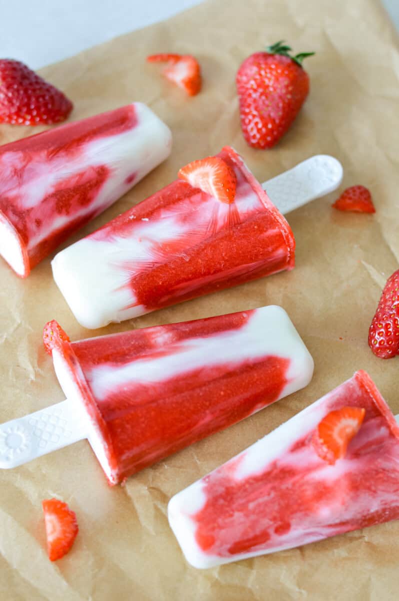 Close up of strawberry fruit popsicles in a line.