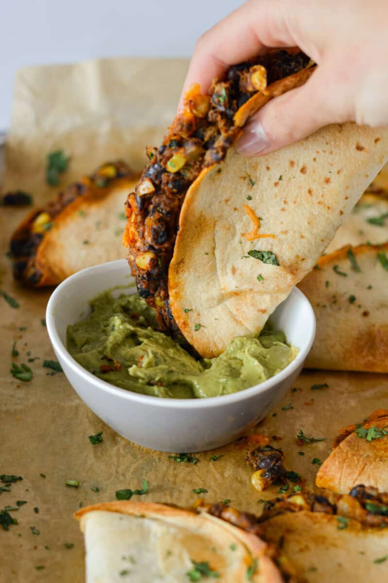 Dipping black bean taco in guac.