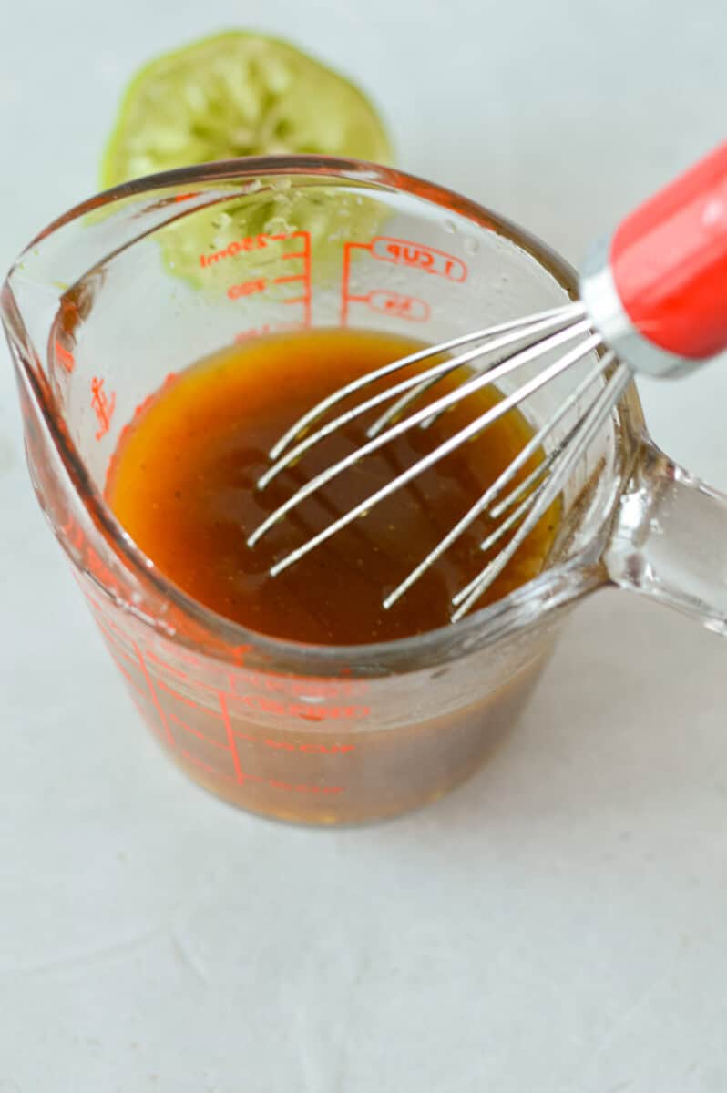 Mixing coleslaw salad dressing in a measuring cup.