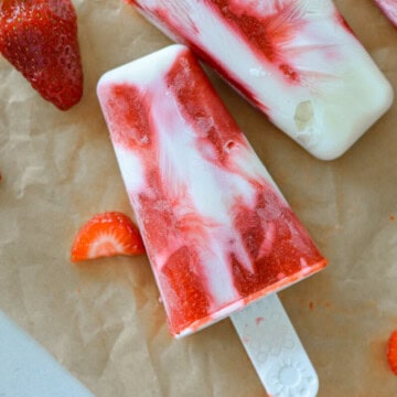 Close up of a strawberry fruit popsicle swirled with greek yogurt.