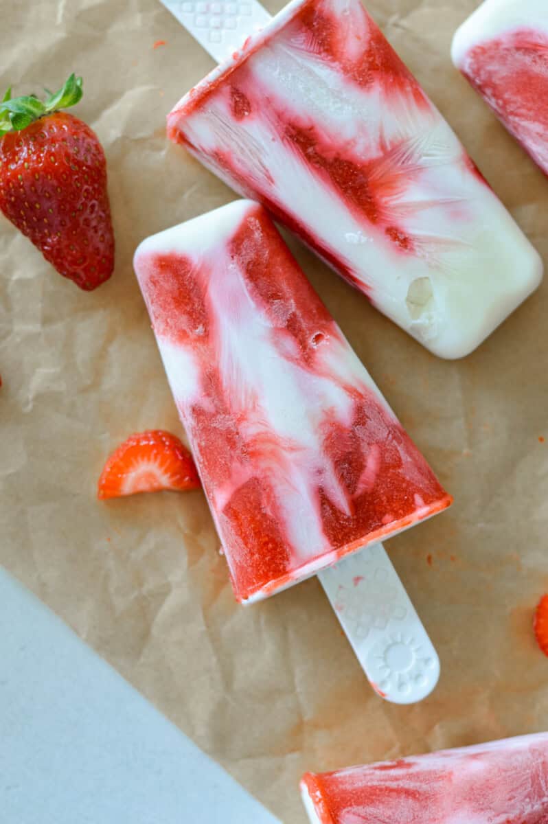 Close up of a strawberry fruit popsicle swirled with greek yogurt.