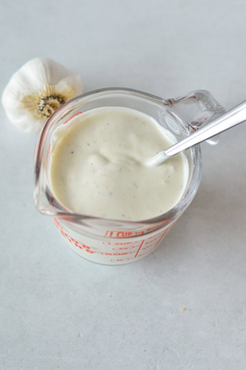 Measuring cup with Greek yogurt salad dressing.