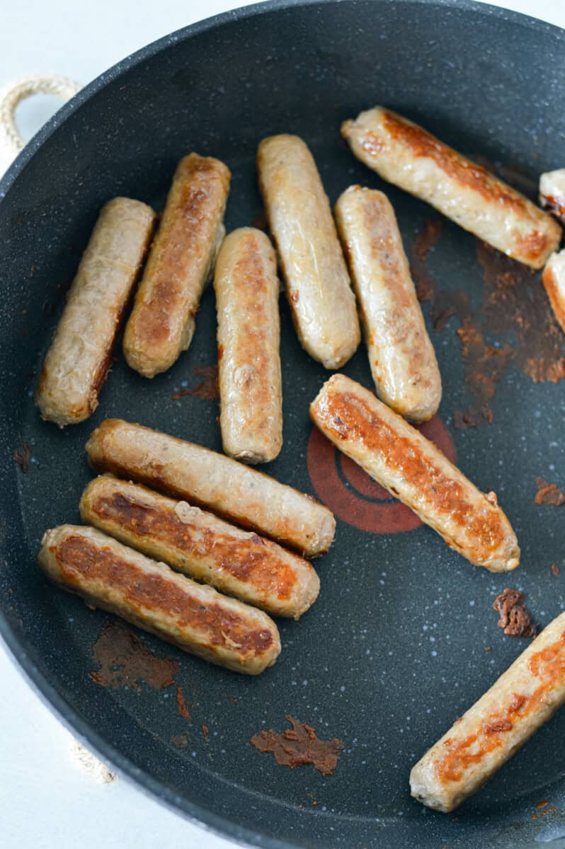 Cooking turkey sausage on a pan.