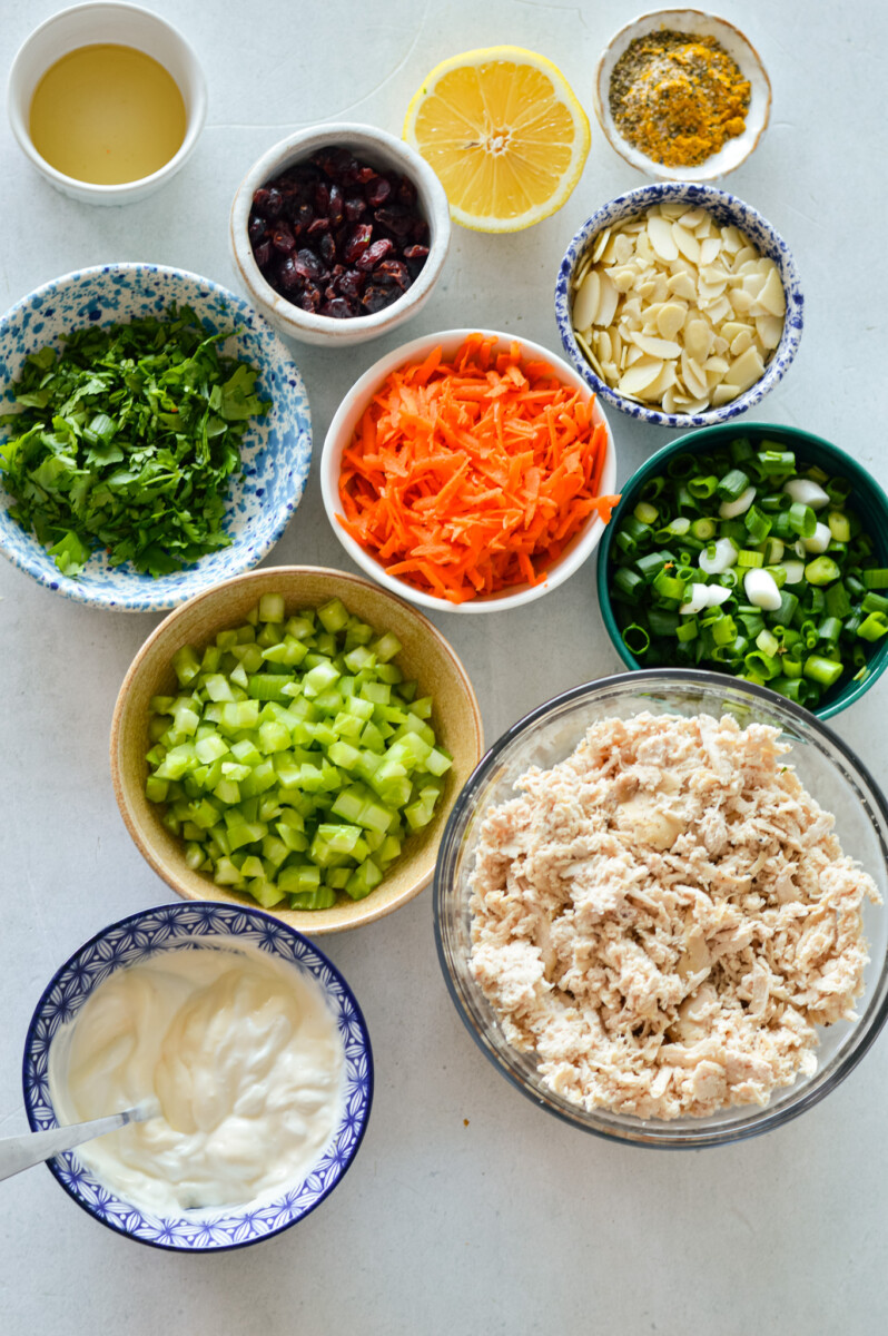 Ingredients including chicken, mayonnaise, greek yogurt, almonds, dried cranberries, cilantro, and curry dressing.