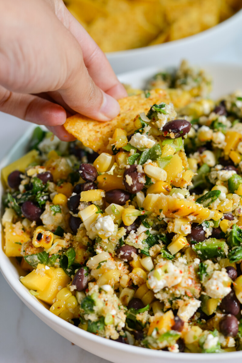Dipping a chip into black bean corn salsa.