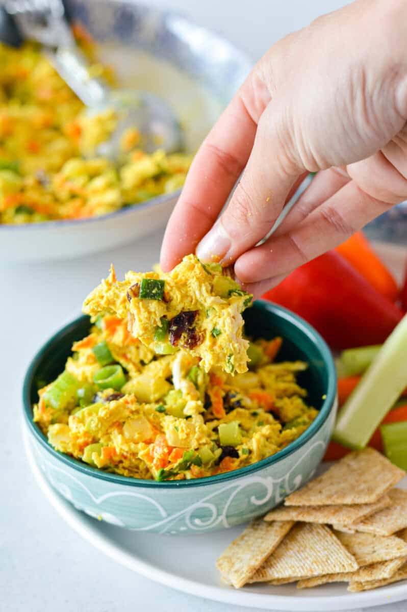 Dipping a cracker into curry chicken salad.