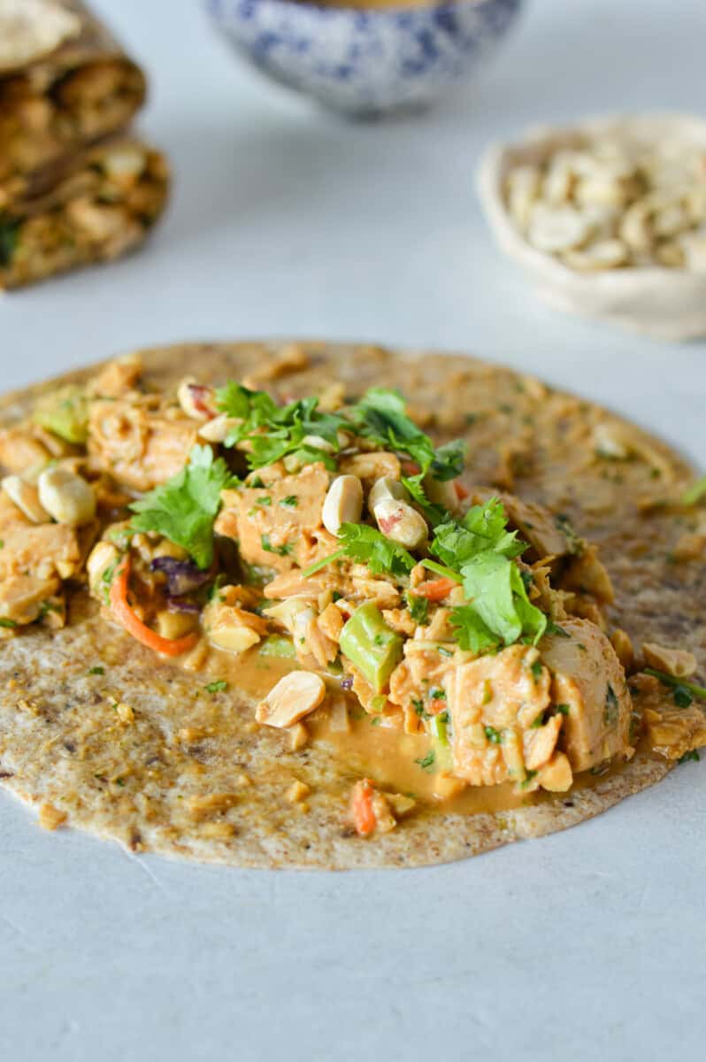 Making a spicy peanut tuna wrap in a tortilla.