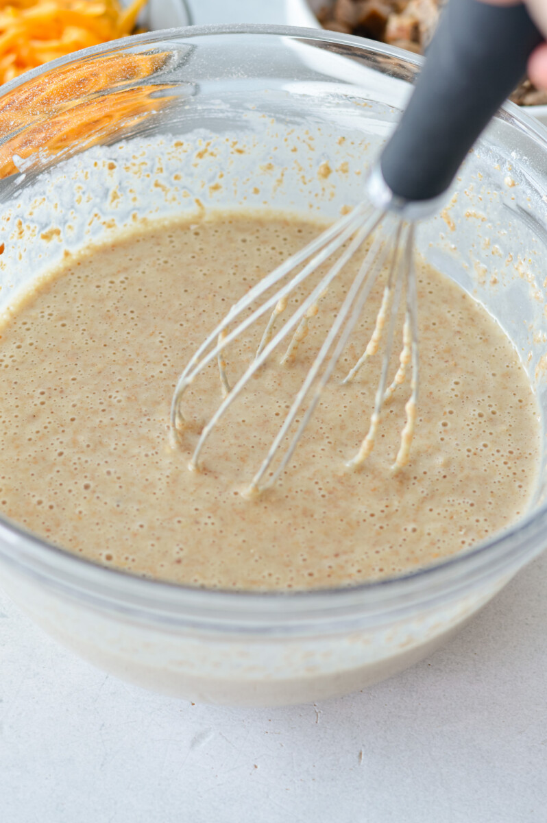 Whisking pancake mix into mcgriddle muffin batter.
