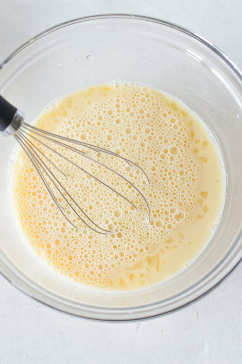 Whisking together milk, eggs and maple syrup.