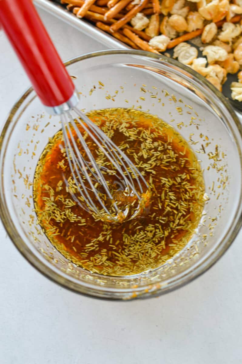 Mixing together olive oil, honey, herbs and spices.