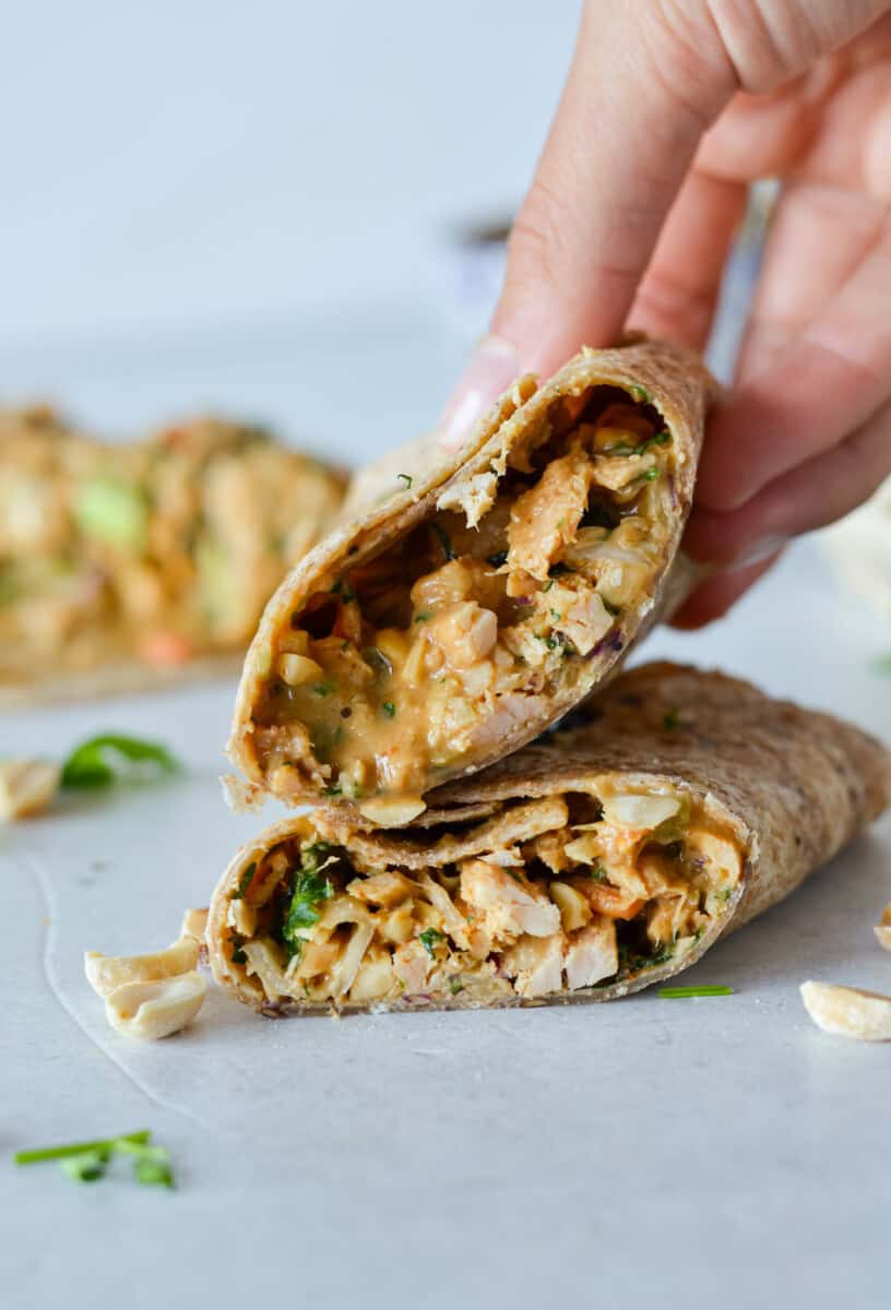 Hand picking up a spicy tuna wrap.