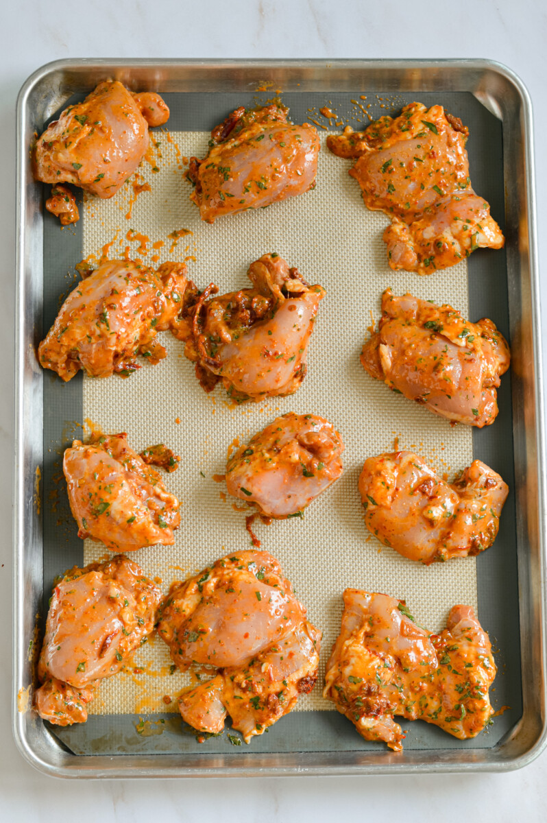 Baking chipotle chicken thighs on a tray.