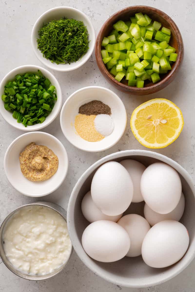 Birds eye of ingredients including boiled eggs, green onion, mustard, spices, lemon and cottage cheese.